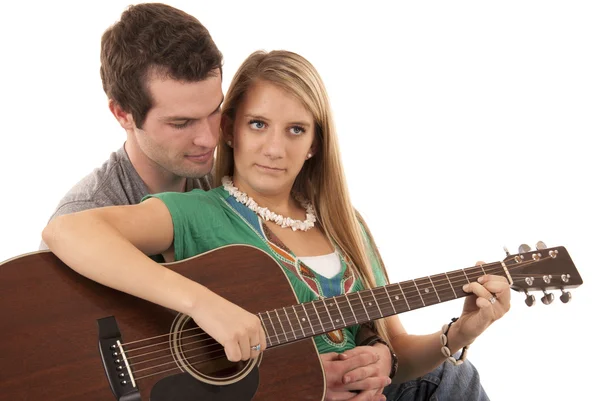 Young couple sitting playing guitar peaceful faces — Stock Photo, Image