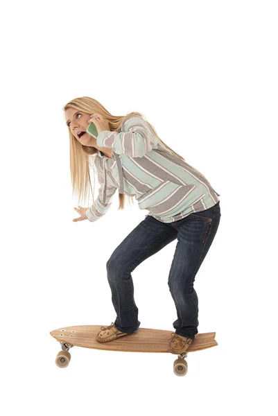 Ung flicka balansera på skateboard talar i mobiltelefon — Stockfoto