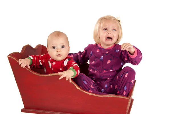 Two toddlers in sleigh one is sad and crying — Stock Photo, Image