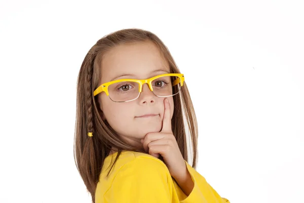 Young girl in yellow glasses posing with finger on cheek — Stock Photo, Image