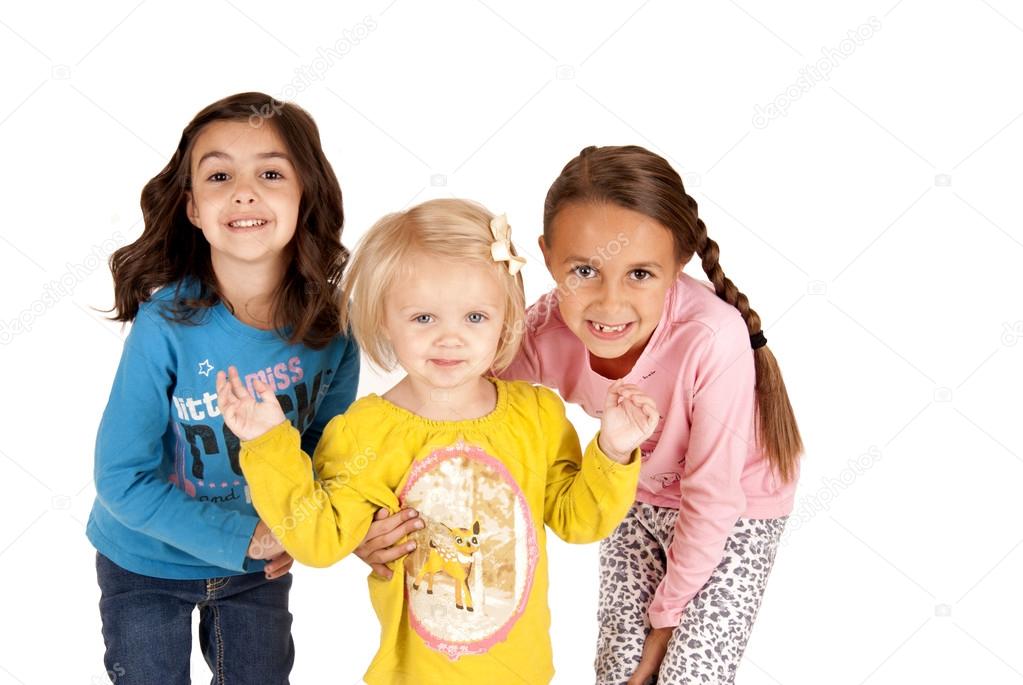 Three cute young girls leaning towards the camera