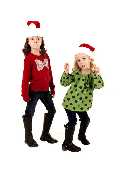 Niedliche Mädchen mit lustigen Ausdrücken in Weihnachtsmannhüten — Stockfoto