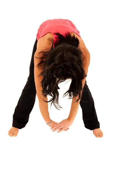 Brünette, fitte Frau streckt sich aus, indem sie sich nach vorne beugt — Stockfoto