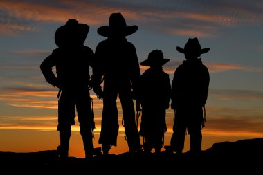 güzel bir günbatımı backgro ile dört genç cowboys silüeti