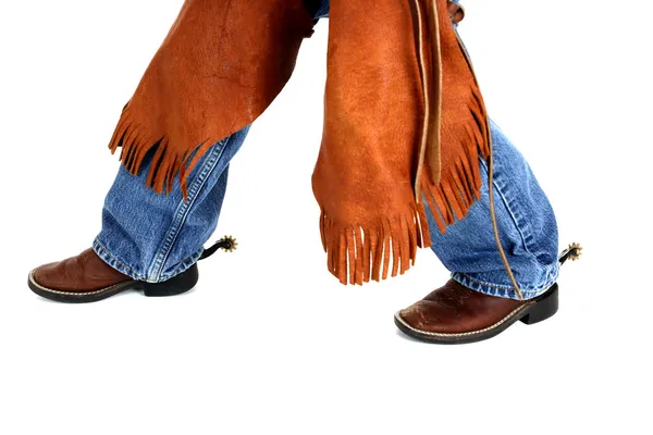 Pernas de um jovem cowboy vestindo chaps esporas e botas — Fotografia de Stock