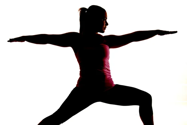 Sihlouette of woman doing yoga exercise called Warrior 2 — Stock Photo, Image