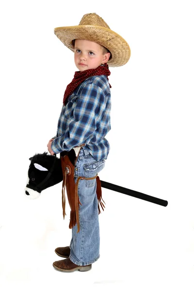 Adorable joven vaquero montando un caballo palo cara seria — Foto de Stock