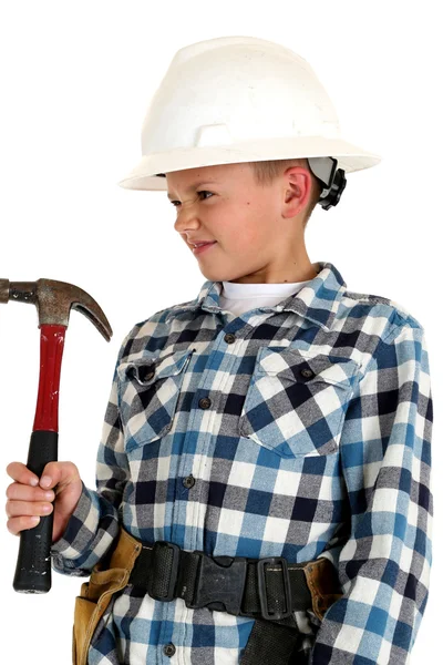 Playful young boy wearing a hardhat and holding a hammer — Stock Photo, Image