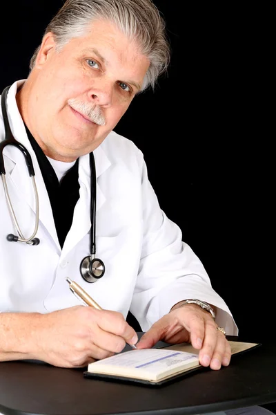 Przystojny dojrzałych lekarza pisanie skryptu — Zdjęcie stockowe