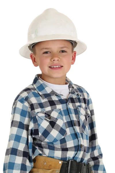 Lindo chico en una construcción hardhat mirando a la cámara sonriendo —  Fotos de Stock