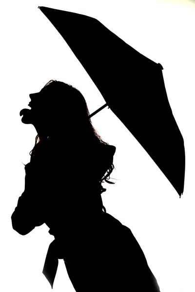 Silhouette of woman sticking out her tongue with an umbrella — Stock Photo, Image