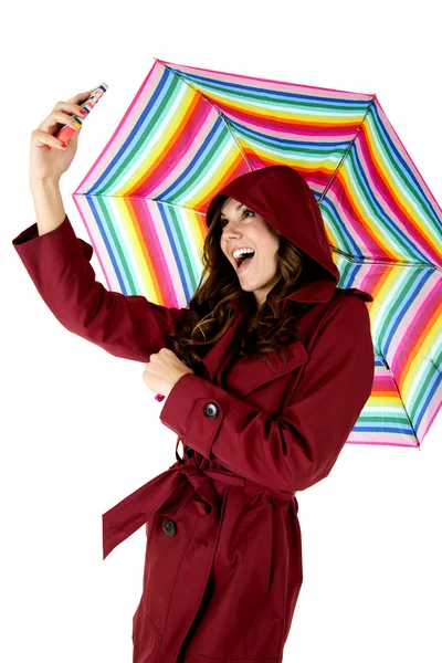 Jolie modèle brune prenant une photo selfie tout en tenant un parapluie de couleur arc-en-ciel — Photo
