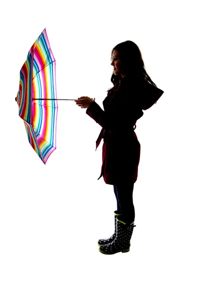 Silhouette of a woman holding a colorful umbrella with a white b — Stock Photo, Image