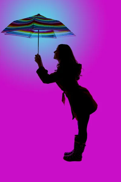Pose divertida y silueta de una mujer sosteniendo un paraguas colorido —  Fotos de Stock