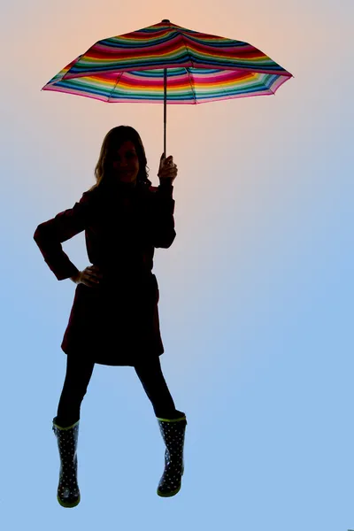 Модель силуэт держа красочный зонтик довольно голубой backgroun — стоковое фото