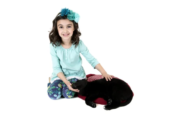 Güzel genç kız evde beslenen hayvan Siyah labrador köpek ile oturuyor — Stok fotoğraf