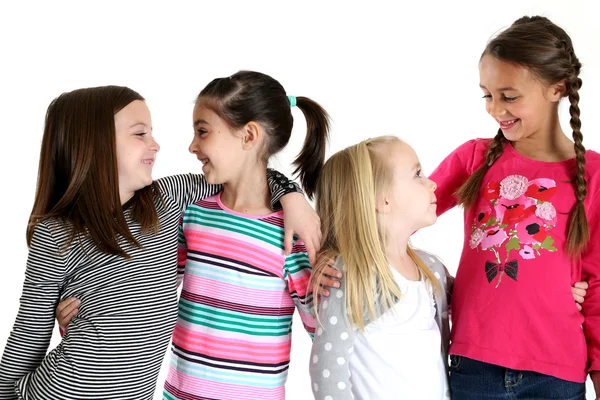 Four cute girls with their arms around each other smiling — Stock Photo, Image