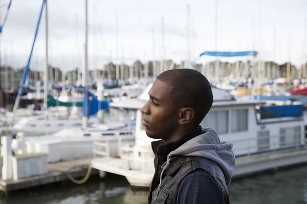African American male model pondering at a boat marina — Stock Photo, Image