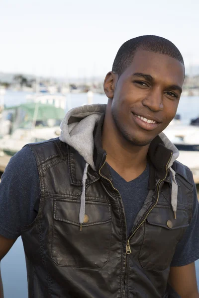 Preto masculino modelo retrato vestindo um colete de couro na marina — Fotografia de Stock