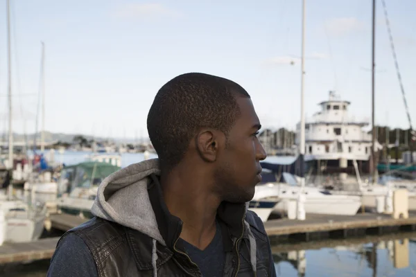 Modelo masculino preto olhando para barcos na marina — Fotografia de Stock