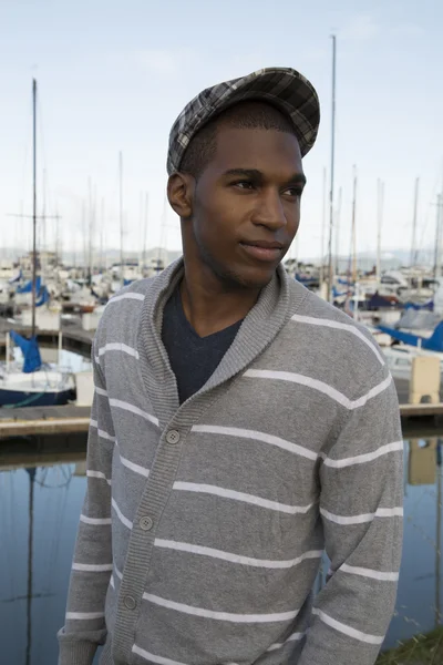 Preto masculino modelo vestindo suéter e newsboy chapéu no beira-mar — Fotografia de Stock