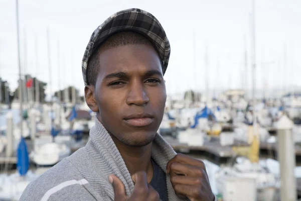 Male model wearing a newsboy cap at the marina — Stock Photo, Image