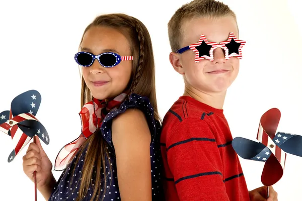 Junge und Mädchen mit patriotischen Windmühlen und Brillen — Stockfoto