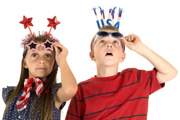 Menino e menina olhando para fogos de artifício usando óculos patrióticos — Fotografia de Stock