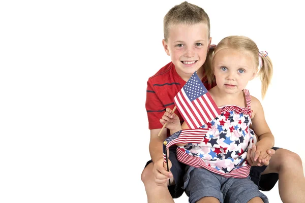 Caucasian boy holding blond blue eyed girl with American flag — Stock Photo, Image