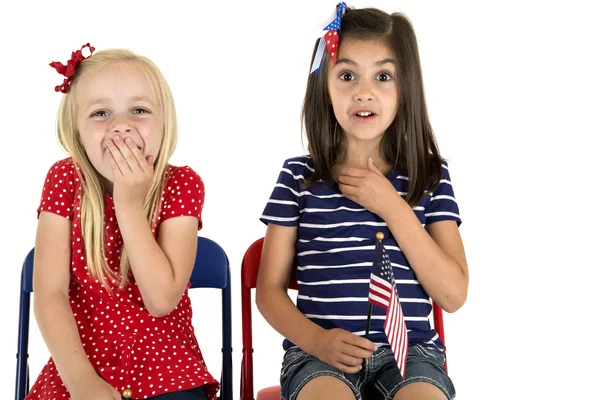 Chicas patrióticas sosteniendo una bandera americana con divertido facial expre — Foto de Stock