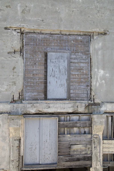 Old rundown warehouse wall with two wood doors — Stock Photo, Image