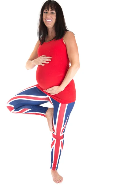 Беременная модель в британских леггинсах, стоящая на одной ноге — стоковое фото