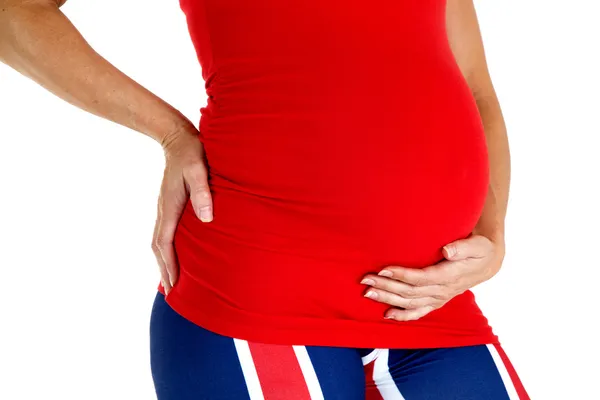 Närbild av en gravid mamma klädd i en röd top — Stockfoto