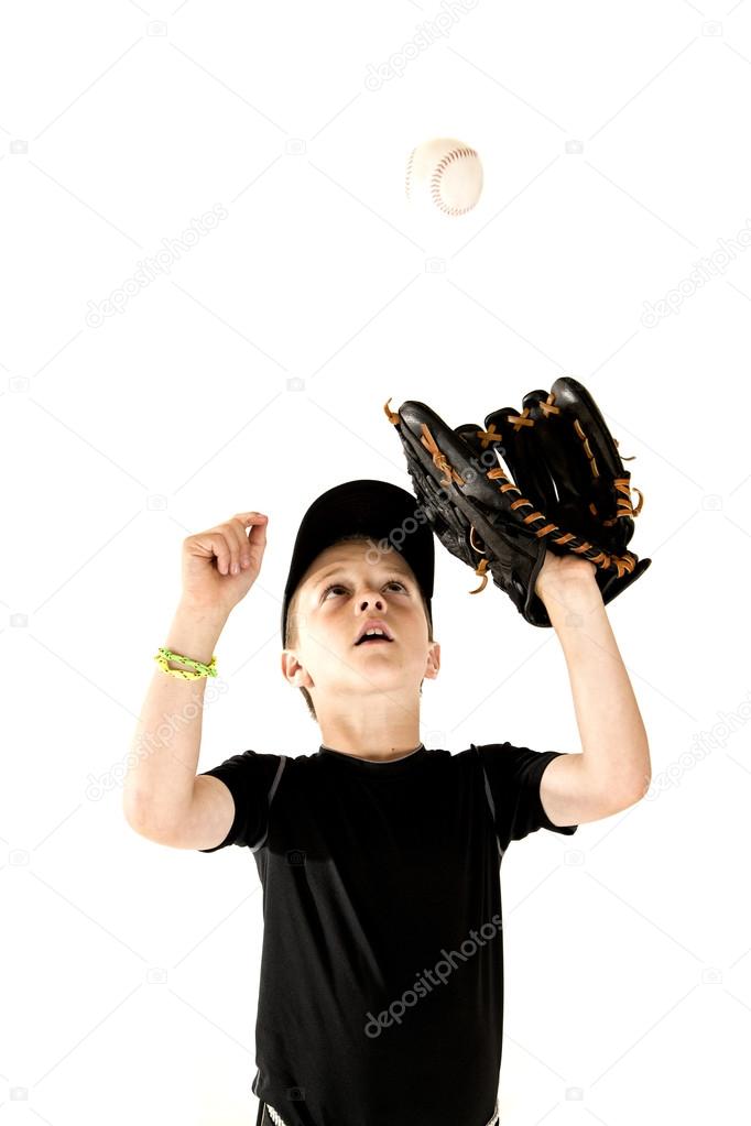 Young boy baseball player focusing on catching the ball