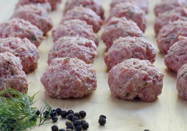 Raw seasoned meatballs on a cutting board — Stock Photo, Image