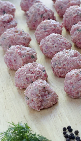 Raw seasoned meatballs on a cutting board — Stock Photo, Image