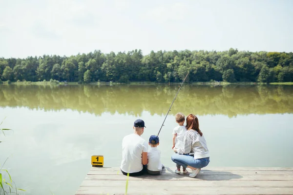 年轻的家人 男人和两个小孩在湖边钓鱼 夫妻在一起度过了一个快乐的周末 — 图库照片