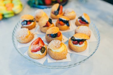 Düğün töreninde farklı renklerde lezzetli tatlılar ve açık büfe masası.