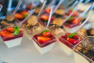 Düğün töreninde farklı renklerde lezzetli tatlılar ve açık büfe masası.