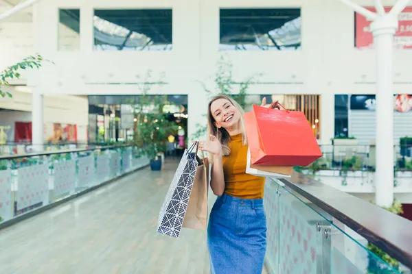 Radosna Młoda Zakupoholiczka Trzymająca Papierowe Torby Zakupami Uśmiechnięta Patrząca Kamerę — Zdjęcie stockowe