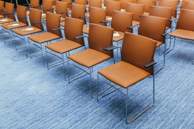 Müzayededen önce turuncu sandalyeli boş bir konferans odası.