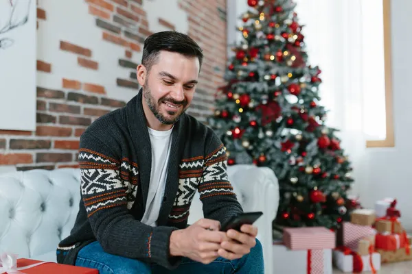 Счастливый Человек Сидящий Дома Диване Переписывается Мобильному Телефону Друзьями Смотрит — стоковое фото
