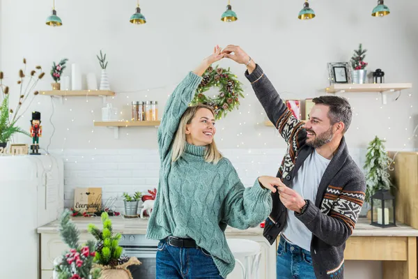 一对年轻夫妇快乐地准备新年和圣诞节的庆祝活动 一家人在厨房里欢欢喜喜地跳舞 — 图库照片