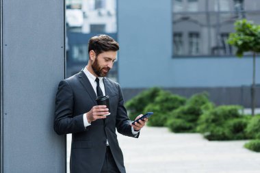 Başarılı iş adamı takım elbiseli bir borsacı dışarıda ofisin yanında telefonla konuşuyor, bankacı öğle arasında elinde bir fincan kahveyle gülümsüyor.