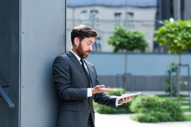 Kızgın mutsuz işadamı dijital tablet akıllı telefon kullanmaktan rahatsız oluyor. Sinirli iş adamı cep telefonu spam mesajıyla sorun yaşıyor. Erkek kullanıcı bataryası ya da dışarıdaki kötü sinyal ofisi yüzünden hayal kırıklığına uğradı