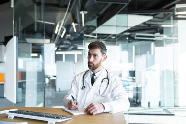 Modern bir klinikte, sakallı başarılı bir olgun doktor. İnternette çalışıyor ve yeteneklerini geliştiriyor.