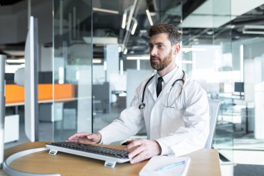 Modern bir klinikte, sakallı başarılı bir olgun doktor. İnternette çalışıyor ve yeteneklerini geliştiriyor.