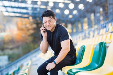 Sporcu doktor çağırır, Asyalı adam koşuda ve sabah antrenmanında bacak kasları sakatlanır, dinlenir, ağır ağrılar çeker.