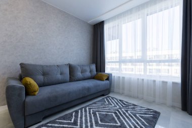 Küçük bir daire, oturma odası stüdyosunun mutfağında mavi bir kanepe.