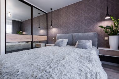 Geniş, çift kişilik yataklı, modern bir otel odası.